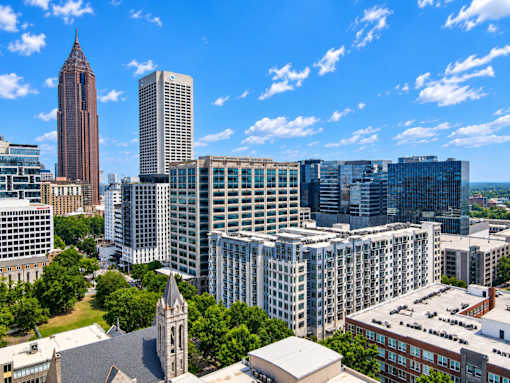 A cityscape with a mix of modern and older buildings under a clear blue sky.