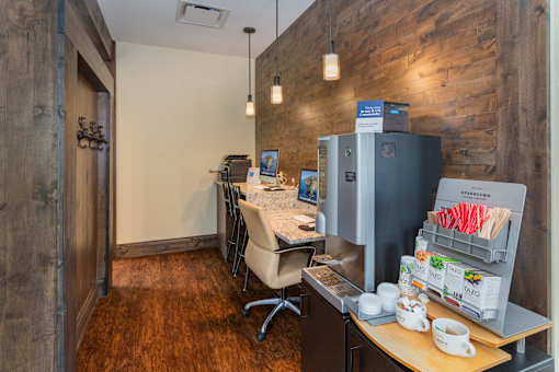 an office with a refrigerator and a desk with a chair and a table with chairs