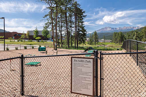 A sign in front of a fence reads "Pet Agility Park".