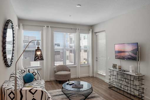 A living room with a sofa, a chair, a coffee table, and a television.