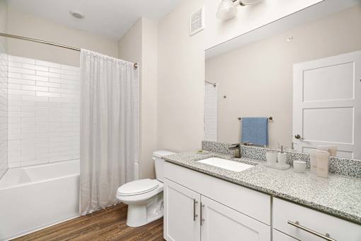 A white bathroom with a toilet, sink, and shower.