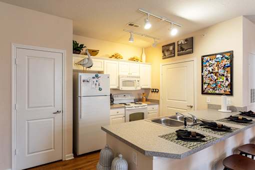 A kitchen with a white fridge and a white door.