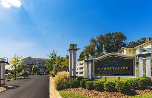 A sign for University Edge stands in front of a building.