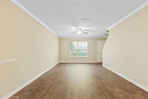 A room with wooden flooring and a ceiling fan.
