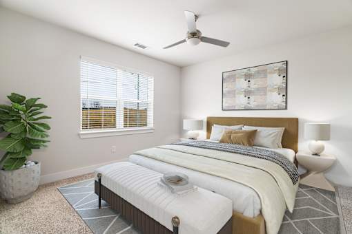 A bedroom with a large bed and a ceiling fan.