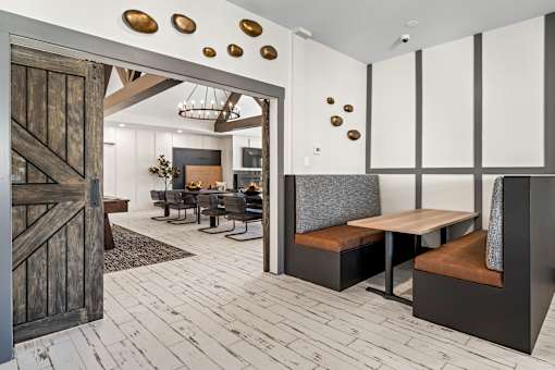 A modern dining room with a wooden floor and a large wooden door.