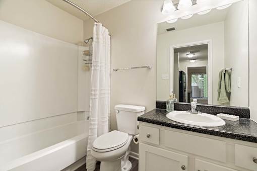 A white toilet sits next to a sink in a bathroom.