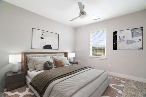 A bedroom with a large bed and two lamps.