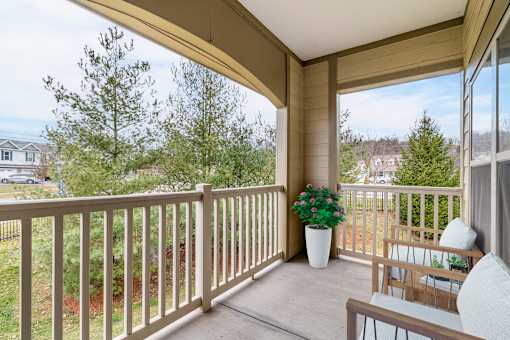 A balcony with a white pillow and a potted plant.