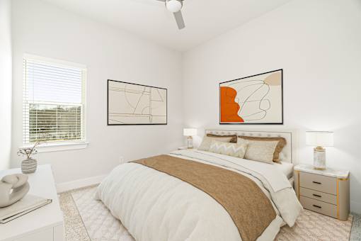 A bedroom with a large bed and two abstract paintings on the wall.