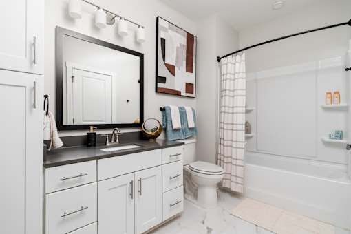 A bathroom with a white toilet and a white shower.