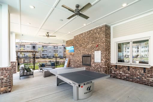 the preserve at ballantyne commons clubhouse with ping pong table and brick fireplace