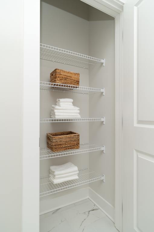 A white refrigerator with a basket and towels on the shelves.