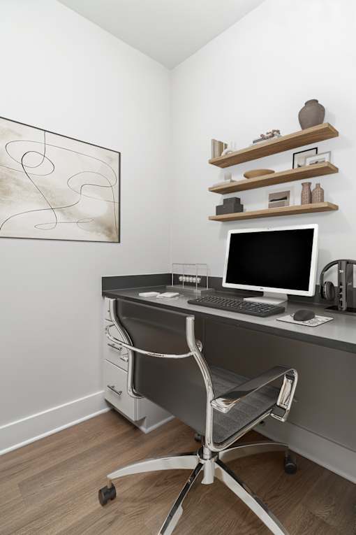 A modern home office with a computer desk and a chair.