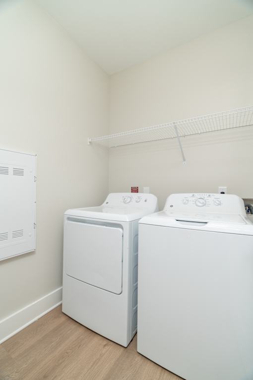 Two white front loading washing machines in a laundry room.