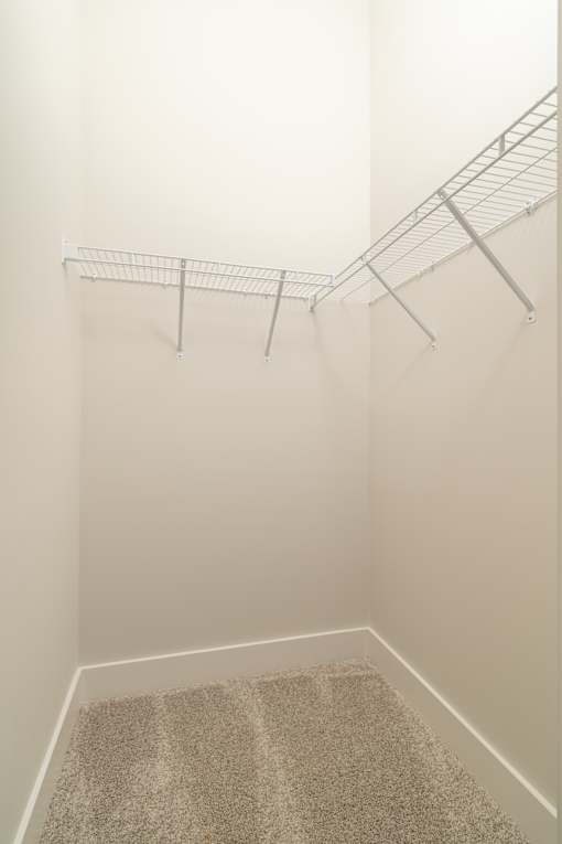 A white metal rack is mounted on a white wall.
