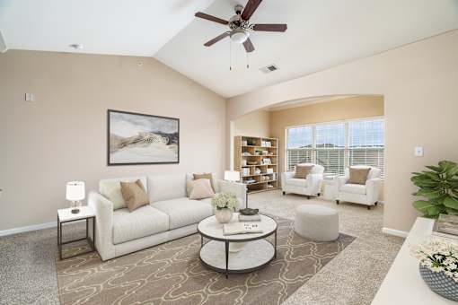 A living room with a white couch, a coffee table, and a ceiling fan.