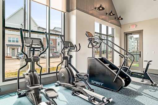 A gym with a row of exercise bikes and a treadmill.
