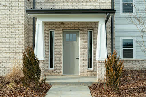 A house with a grey door and two windows.