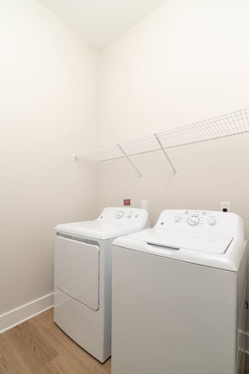 Two white front loading washing machines in a laundry room.