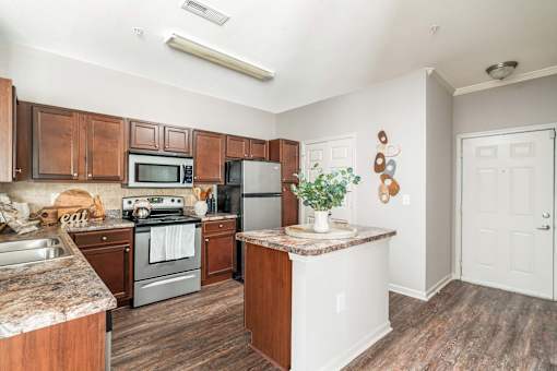 A kitchen with wooden cabinets and a granite countertop.