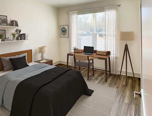 A bedroom with a bed, desk, and chair.