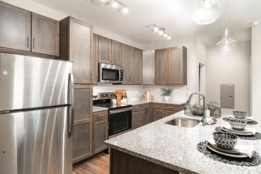 Luxury Apartments in Alcoa, TN, with In-Unit Washer and Dryer - Vintage Hunters Crossing - Kitchen with Island, Shaker-Style Wood Cabinetry, Granite Countertops, and Stainless Steel Appliances.