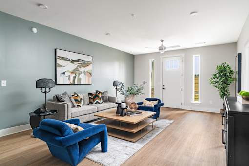 A living room with a blue chair and a grey couch.
