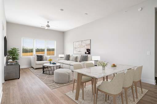 A modern living room with a white dining table and chairs.