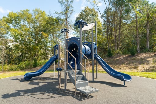 a playground with a set of slides in a park
