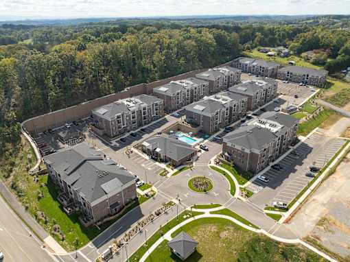 Aerial view of apartment complex with green spaces, walking paths, and pools in West Knoxville, TN.