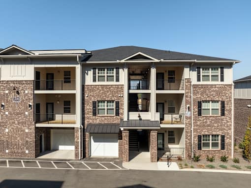 A large brick apartment building with multiple balconies and doors.