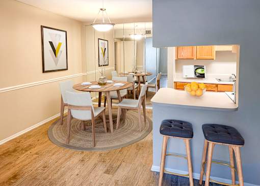 A kitchen with a dining table and chairs.