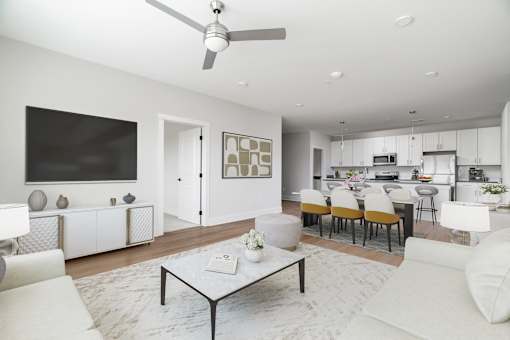 A modern living room with a white sofa set and a coffee table.