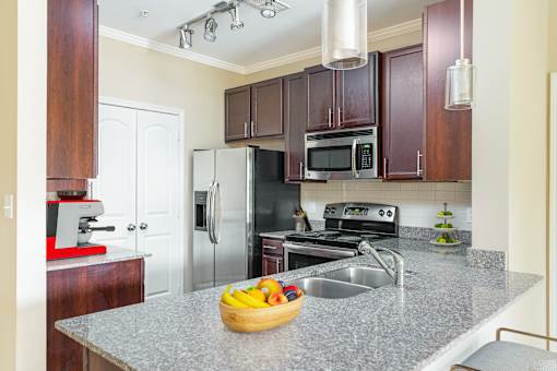 A kitchen with a granite countertop and stainless steel appliances.
