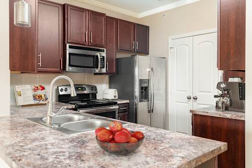 A kitchen with a bowl of fruit on the counter.