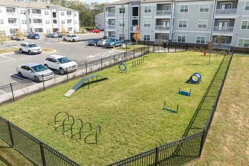 a playground in an apartment complex with cars parked in a parking lot