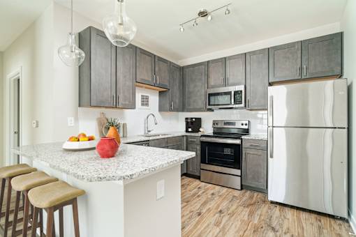 A kitchen with a granite countertop and stainless steel appliances.