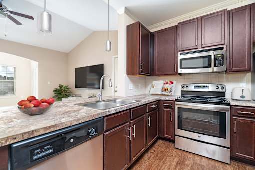A kitchen with brown cabinets and a black stove top oven.