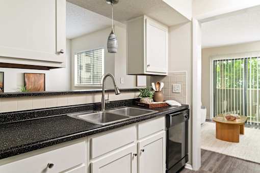 A kitchen with black countertops and white cabinets.