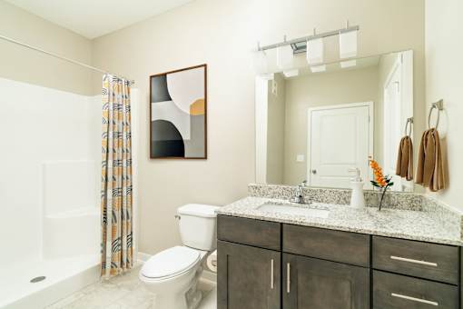 A bathroom with a toilet, sink, and shower.