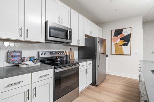 A modern kitchen with white cabinets and stainless steel appliances.