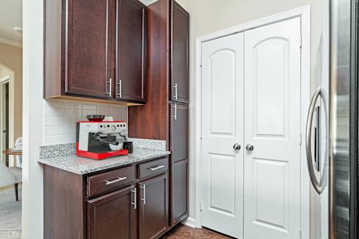 A kitchen with brown cabinets and a white fridge.