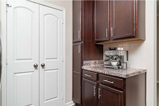 A kitchen with brown cabinets and a marble countertop.