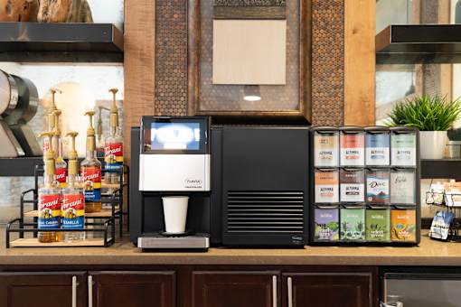 A coffee machine is on a counter with a variety of coffee pods.