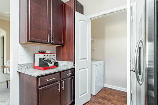 A kitchen with brown cabinets and a red microwave oven.