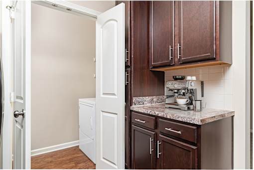 A kitchen with brown cabinets and a white refrigerator.