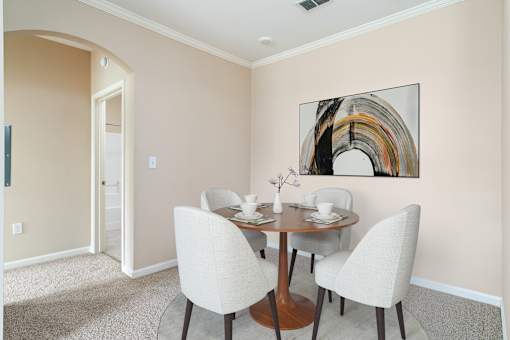 A dining room with a round table and chairs.