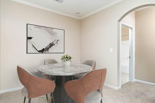A dining room with a round table and chairs.