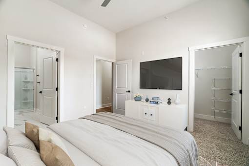 A bedroom with a bed, a television, and a cabinet.